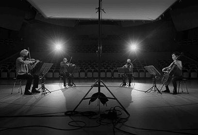 black-and-white photo of Kronos Quartet performing on stage